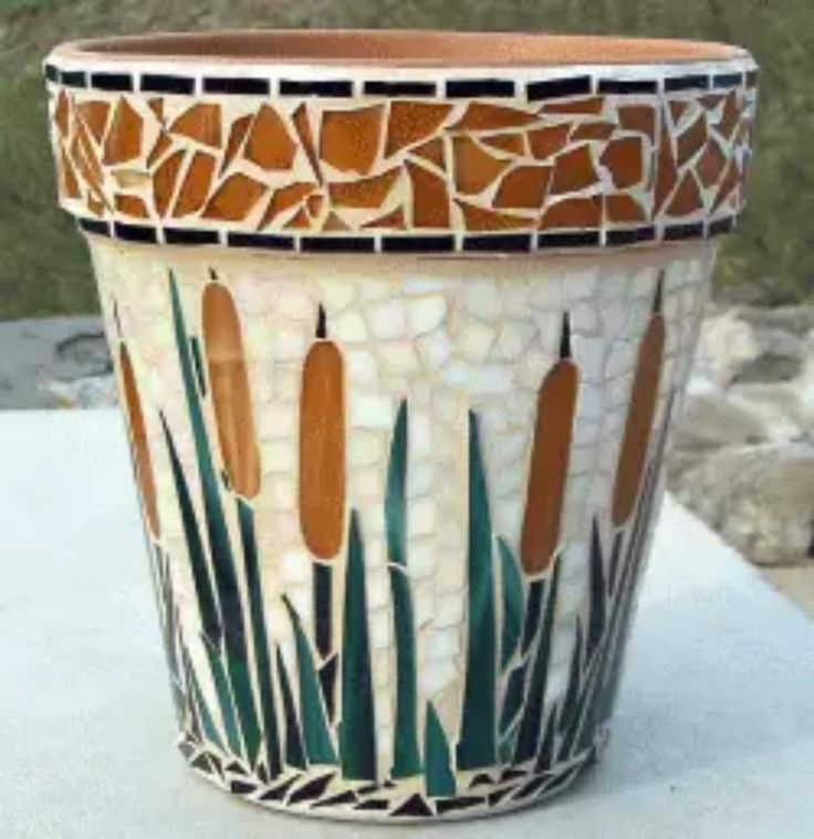 a planter that is sitting on a table with grass and rocks in the background