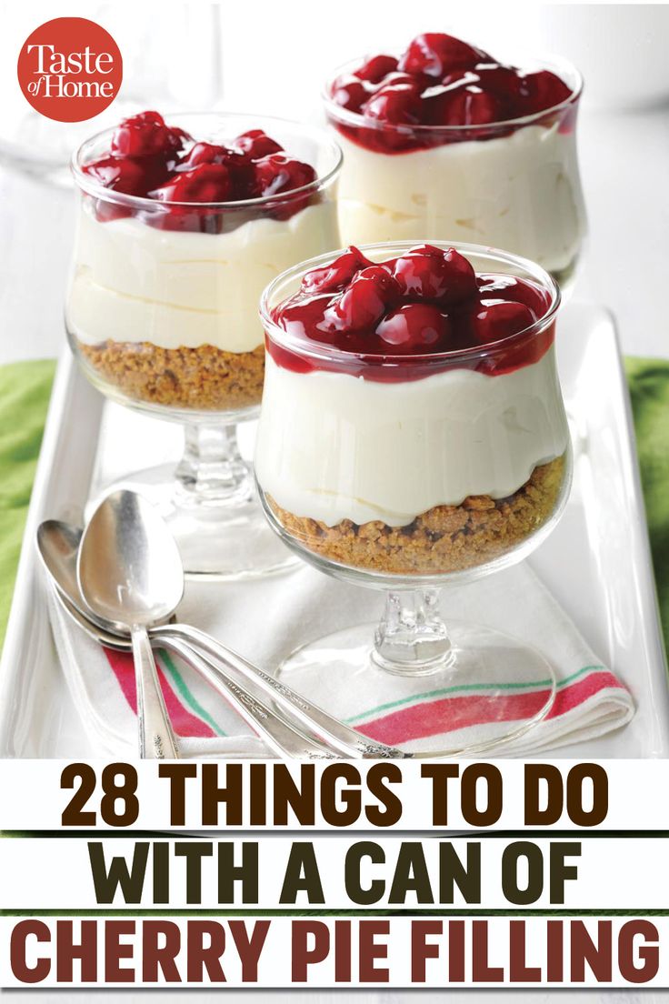 three desserts with cherries in small glass dishes on a white tray next to silverware