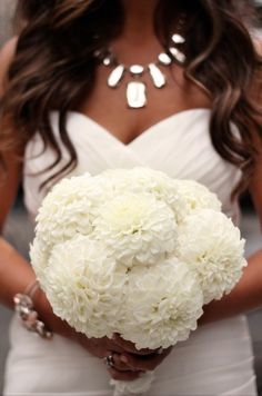 a woman holding a bouquet of white flowers