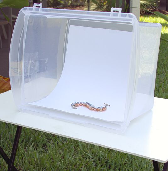 an empty white box sitting on top of a table in the middle of some grass