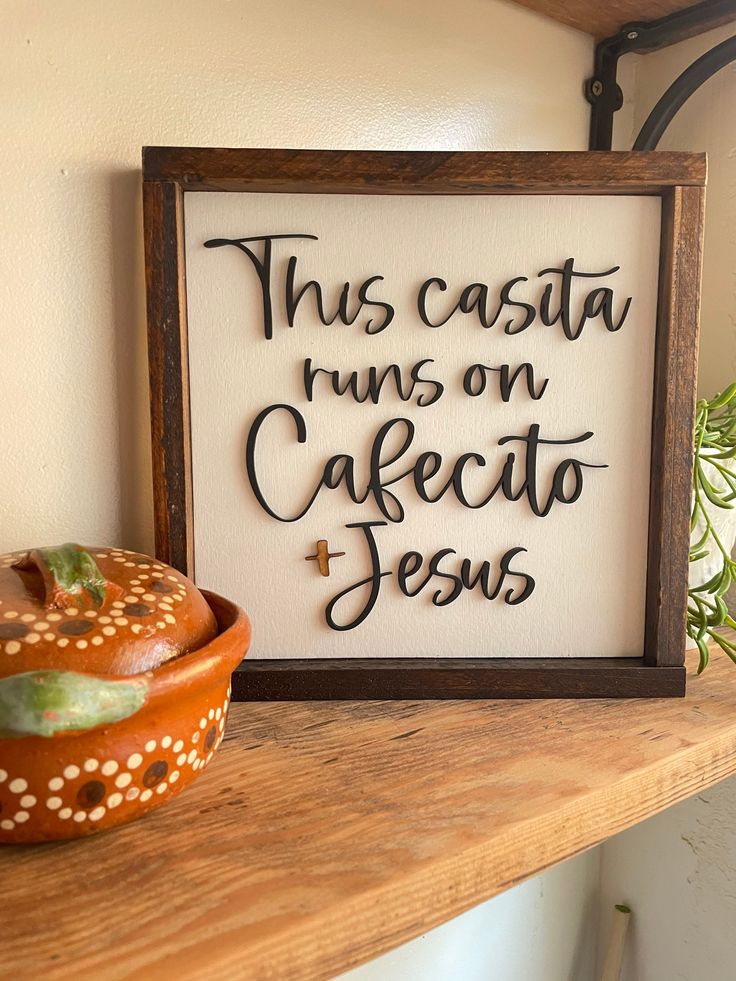 this casta runs on cafeato jesus sign next to a ceramic bowl and potted plant