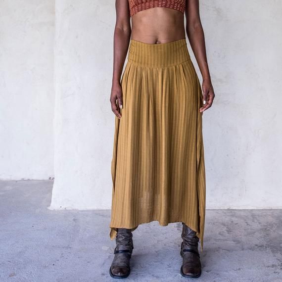 The IDIS Abby Skirt in Tumeric is a Mid rise skirt with high side splits and smocking in the back creating an elasticised waiste band for extra comfort.Made from a medium weight woven Rayon.Part of the Graceful Rebellion Range.SIZE GUIDE XS: bust 76-82 cm | waist 64-70 cm | hips 78-84 cmS: bust 82-84 cm | waist 70-76 cm | hips 84-90 cmM: bust 84-88 cm | waist 76-82 cm | hips 90-96 cmL: bust 94-100 cm | waist 82-88 cm | hips 96-102 cmXL: bust 100-106 cm | waist 88-104 cm | hips 102-108 cmDELIVERY Asymmetrical Relaxed Maxi Skirt With Elastic Waistband, Asymmetrical Maxi Skirt With Elastic Waistband, Summer Pleated Hip-length Skirt, Summer Hip-length Pleated Skirt, Asymmetrical Relaxed Maxi Skirt With Side Slits, Casual Asymmetrical Maxi Skirt With Gathered Detail, Casual Asymmetrical Gathered Maxi Skirt, Casual Pleated Asymmetrical Skirt, Bohemian Pleated Midi Skirt