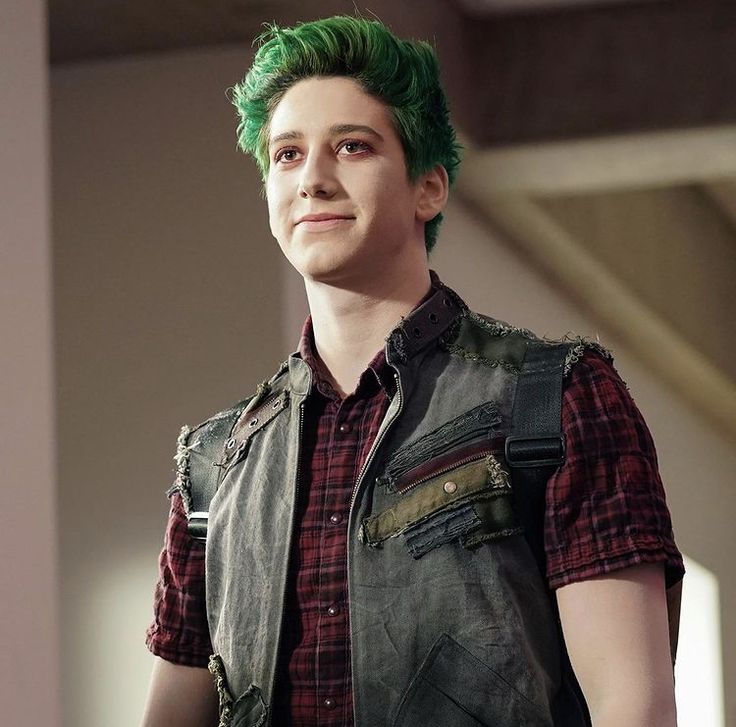 a man with green hair wearing a leather vest