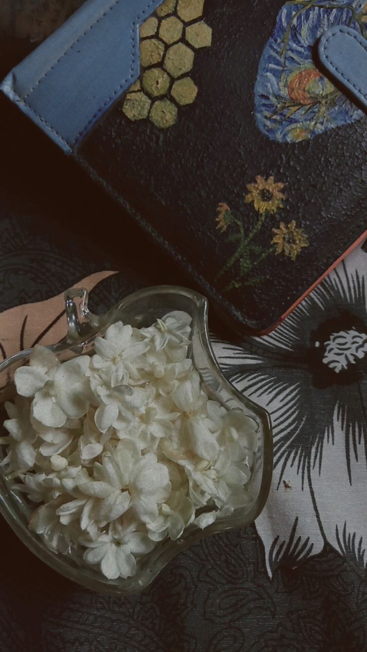 a bowl filled with food sitting on top of a table next to an open purse