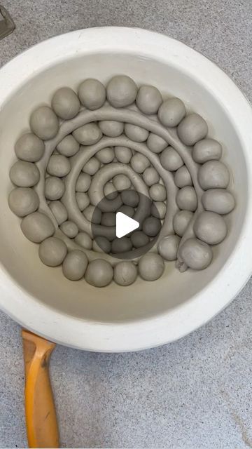 a white bowl filled with balls and a wooden spoon