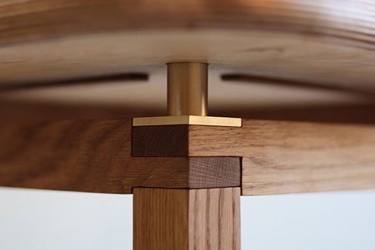 a close up view of the wood and metal posts on a wooden bed frame with white walls in the background