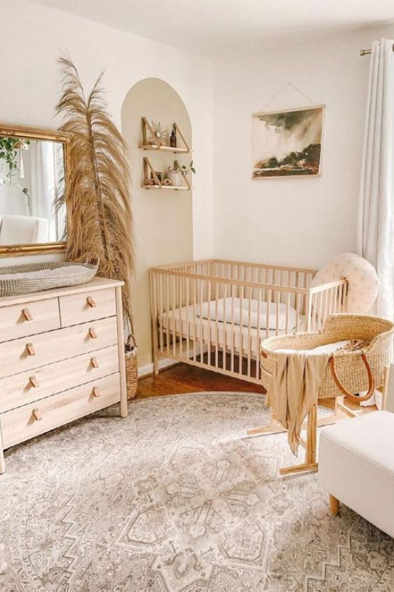 a baby's room with a crib, dresser and chair in it that has a mirror on the wall