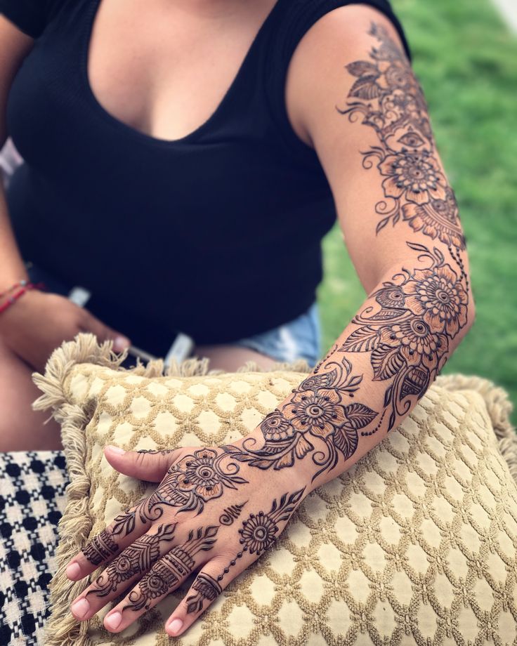 a woman with henna on her arm holding a pillow