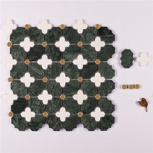 a piece of green and white tile with gold dots on it, next to two pieces of black and white tiles