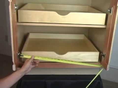 someone is measuring the width of an open cabinet with a yellow tape on it's edge