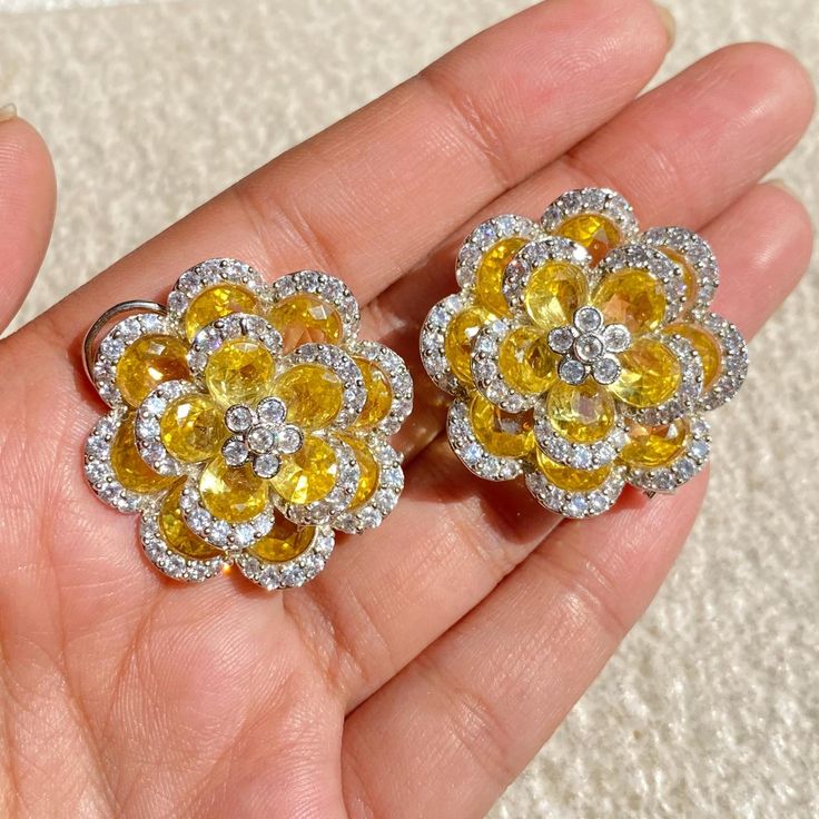 Yellow canary Stud Earrings featuring semi precious yellow blue stone with cz diamonds in a floral design. These PREMIUM QUALITY earrings can be apart from each others and you can wear these earrings in a multiple ways and create multiple looks. Perfect gift for her. *𝐏𝐑𝐎𝐃𝐔𝐂𝐓 𝐃𝐄𝐓𝐀𝐈𝐋* * 𝐌𝐚𝐭𝐞𝐫𝐢𝐚𝐥: Brass * 𝐏𝐥𝐚𝐭𝐢𝐧𝐠: White Rhodium Plated * 𝐒𝐭𝐨𝐧𝐞: AAA-quality CZ Diamond. *𝐃𝐈𝐌𝐄𝐍𝐒𝐈𝐎𝐍𝐒* * 𝐖𝐞𝐢𝐠𝐡𝐭: 8 gm each * 𝐋𝐞𝐧𝐠𝐭𝐡: 1.15 Inches * 𝐖𝐢𝐝𝐭𝐡:  1.15 In Yellow Diamond Earrings With Accents For Wedding, Yellow Diamond Earrings With Diamond Accents For Wedding, Wedding Yellow Diamond Earrings With Accents, Luxury Yellow Diamond Earrings For Wedding, Yellow Diamond Earrings With Gemstone, Diamond Flower Cluster Earrings For Wedding, Luxury Cubic Zirconia Flower Earrings, Yellow Flower-shaped Formal Jewelry, Formal Yellow Flower-shaped Jewelry