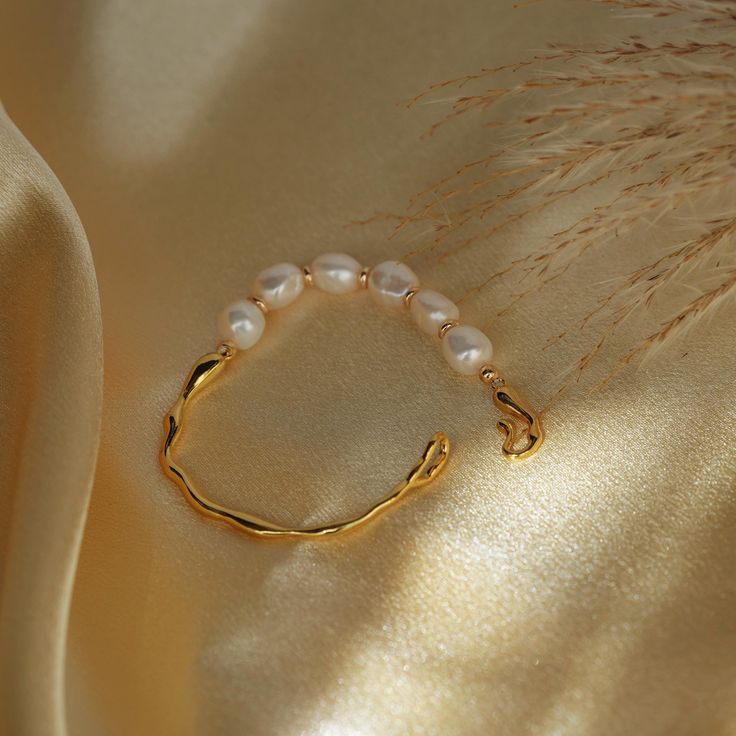 This stunning Freshwater Pearl & Gold Plated Bracelet features lustrous freshwater pearls, each separated by delicate gold beads, strung on a beautifully textured gold-plated band. With a secure and easy-to-use clasp for effortless wear, this piece is a must-have accessory for any occasion. 💖Please be aware that natural pearls may exhibit variations in shape and minor surface irregularities, serving as evidence of their organic origin. ✨Specifications: - Length: 18 cm (We recommend measuring fo Elegant Gold Bracelet With Baroque Pearl, Gold Pearl Bracelet With Oyster Detail, Baroque Pearl Bracelets For Wedding, Yellow Gold Baroque Pearl Chain Bracelet, Baroque Pearl Wedding Bracelets, Elegant Gold Baroque Pearl Bracelet, Gold Pearl Bracelet With Oyster Design, Delicate Baroque Pearl Bracelet With Pearl Chain, Delicate Baroque Pearl Chain Bracelet