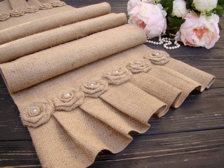 four pieces of burlocked fabric with pearls and flowers on the table next to them