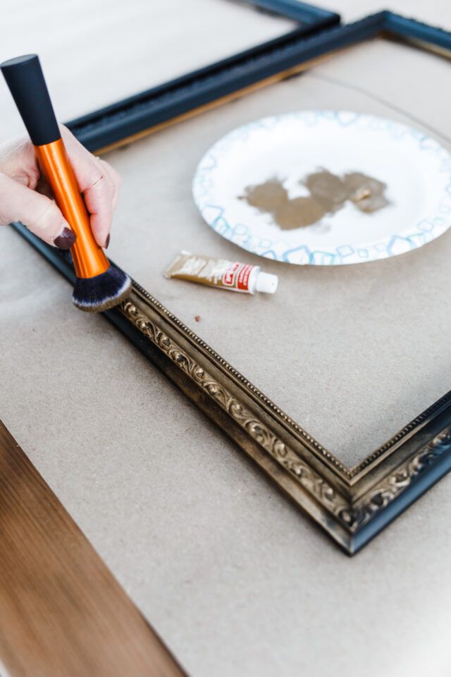 a person is painting a picture on the table with paintbrushes and an orange tube