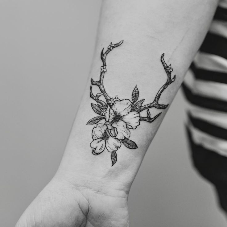 a woman's arm with a flower tattoo on the left side of her wrist