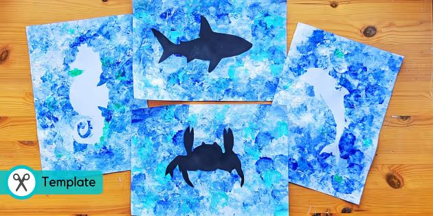 four pieces of paper cut out to look like silhouettes of sharks and sea creatures