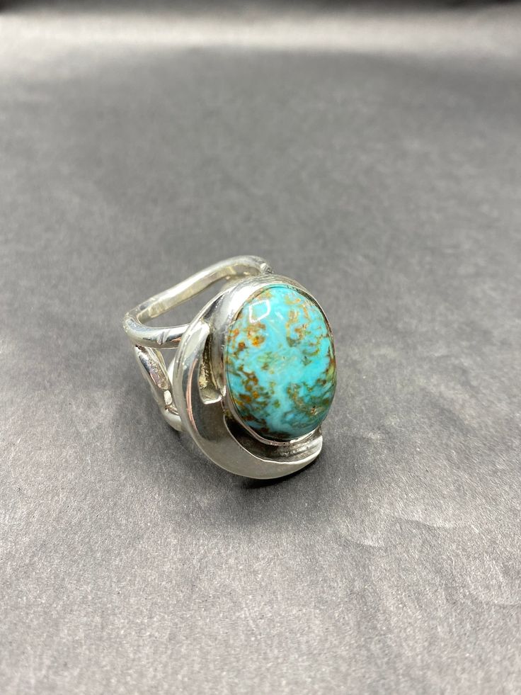 This is a truly unique Hidden Valley Turquoise ring with a semi-circle asymmetrical setting. The band is equally special, having handmade designs with an open air feel. This ring is substantial, weighing over 20 grams. * Sterling silver (925) band * ring size 6 * 20.2 grams total weight * 13 mm band width (at widest) * turquoise stone 16mm x 11mm This is a completely custom design, made entirely by Michael Presley from concept to completion. Michael's personal style reflects commitment to qualit Modernist Turquoise Jewelry Gift, Modern Turquoise Ring With Polished Finish, Modern Oval Turquoise Jewelry, Modern Round Turquoise Jewelry, Modern Turquoise Oval Jewelry, Modern Turquoise Anniversary Ring, Modern Turquoise Round Jewelry, Unique Turquoise Rings With Polished Finish, Fusion Style Oval Rings With Polished Finish