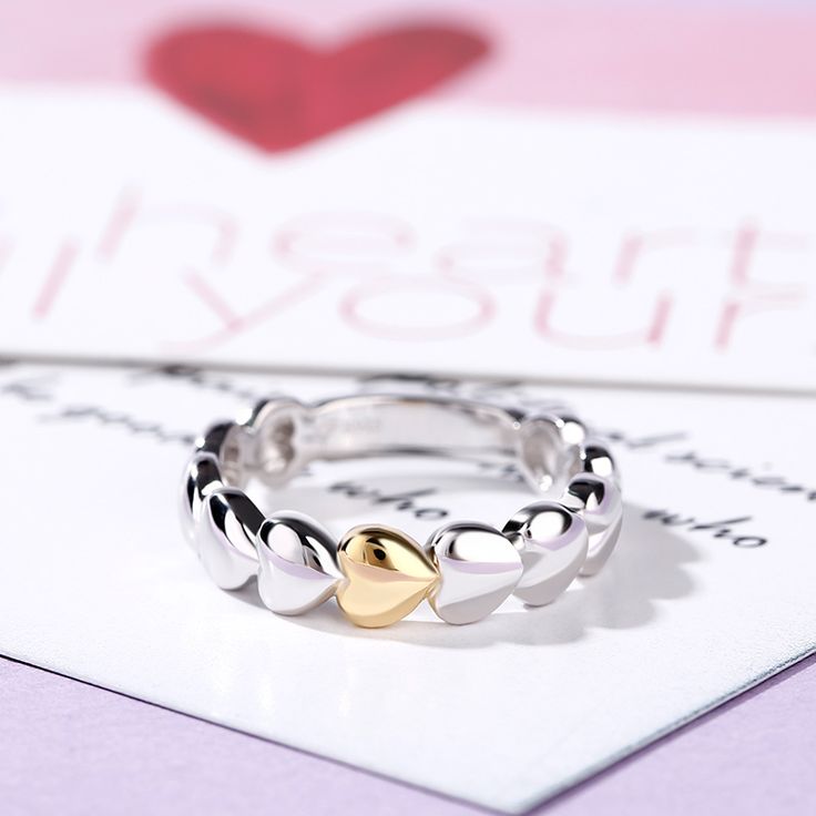 Dainty and delicate, this heart ring makes a little lovely gift for loved one or yourself. Heart is one of the most popular motifs in jewelry that often related with love.This ring sculptures a series of heart shapes. Crafted in two tone sterling silver, the only one heart featured gold tone makes it special.This band is a beautiful reminder of your timeless romance.Weight: 3.89 gWidth: 3.2 mmThickness: 1.6 mmMaterial: 925 SilverPlating Color: Silver, Yellow Gold Quality Jewelry, Heart Shape, Lovely Gift, Heart Ring, Heart Shapes, Two Tone, Bespoke, Most Popular, Gold Tones