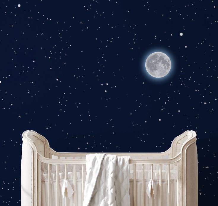 an empty crib in front of a night sky with the moon and stars above it