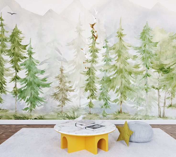 a room with trees painted on the wall and a round table in front of it