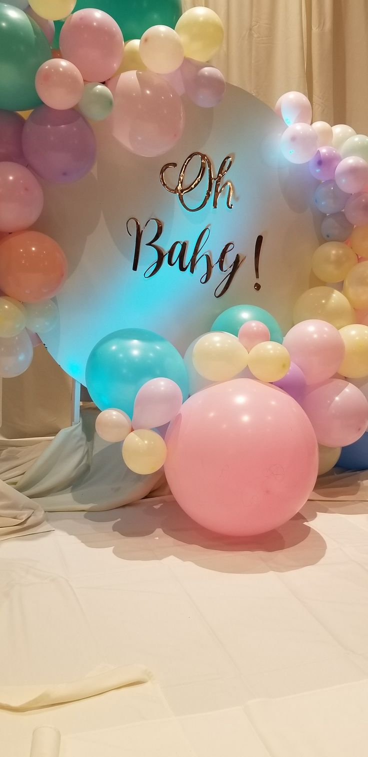 balloons and streamers are on the table for an oh baby sign at a party