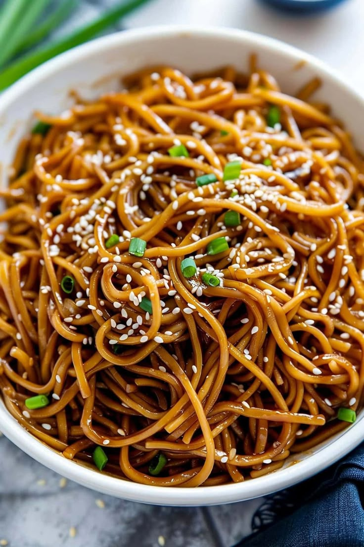 a white bowl filled with sesame seed noodles