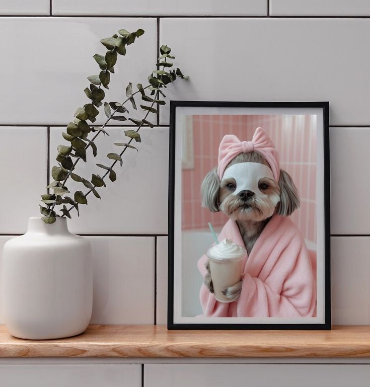 a small dog in a pink robe holding a cup