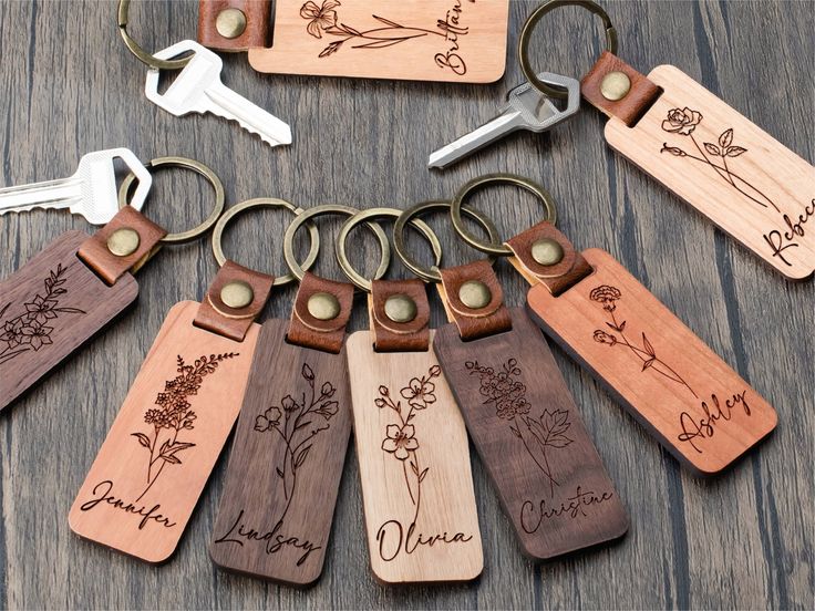 wooden keychains with engraved names and flowers on them are arranged in a circle