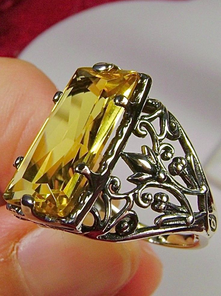 Yellow Citrine Ring Baguette Design#32 Introducing the Baguette D32, a stunning piece of wearable art that pays homage to the opulent Victorian era. Crafted with meticulous attention to detail, this exquisite filigree Antique reproduction in sterling silver is sure to captivate anyone with a love for vintage-inspired jewelry. At its center, lies a flawless 7ct yellow gemstone, radiating a dazzling hue that catches the light with every movement. The baguette rectangle-cut gemstone measures a rema Elegant Yellow Citrine Jewelry, Yellow Rectangular Stone Ring For Gift, Yellow Rectangular Stone Ring Gift, Rectangular Stone Yellow Ring Gift, Yellow Rectangular Gemstone Rings, Luxury Yellow Baguette Cut Jewelry, Formal Yellow Baguette Cut Jewelry, Yellow Citrine Rectangular Rings, Yellow Rectangular Citrine Ring