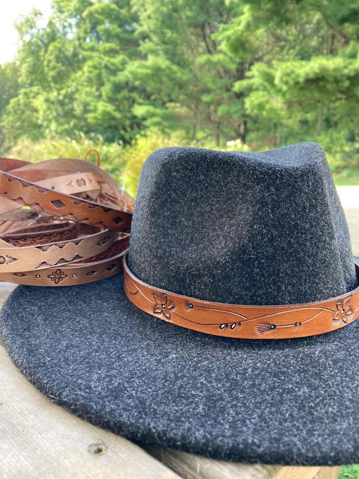 Hand-designed and tooled leather hat bands for your cowboy or rancher hat. These measure about 23.5 inches long and have an adjustable tie at the ends. Rustic Leather Fedora With Adjustable Fit, Adjustable Western Hat Bands For Fall, Adjustable Country Hat Bands For Fall, Adjustable Hat Bands For Country Events In Fall, Adjustable Hat Bands For Fall Outdoor Events, Adjustable Hat Bands For Outdoor Fall Activities, Leather Adjustable Fedora For Ranch, Leather Fedora For Ranch, Adjustable Leather Country Hat Bands