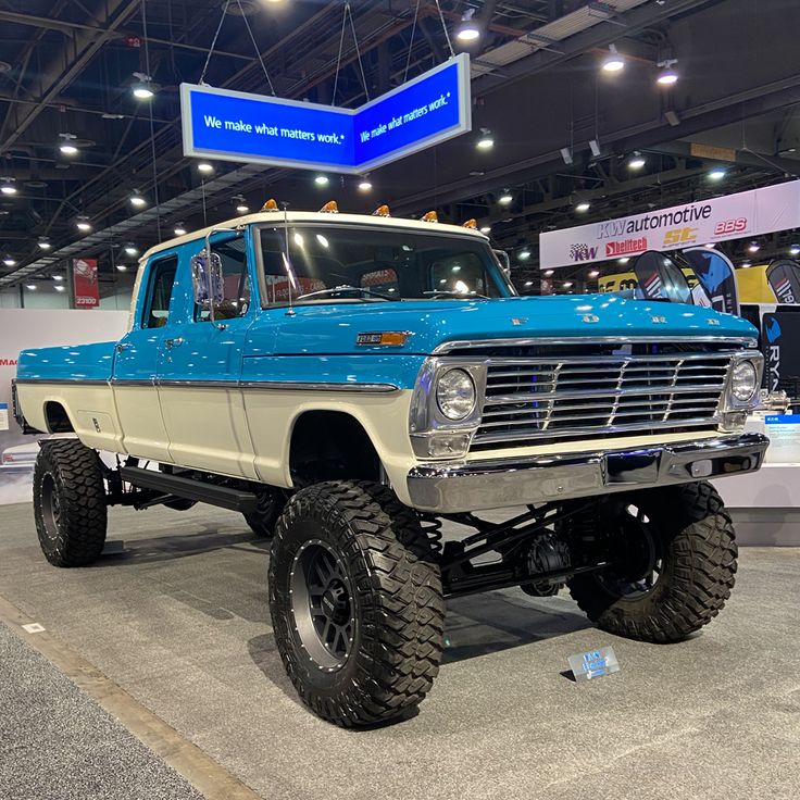 a blue and white truck on display at a car show