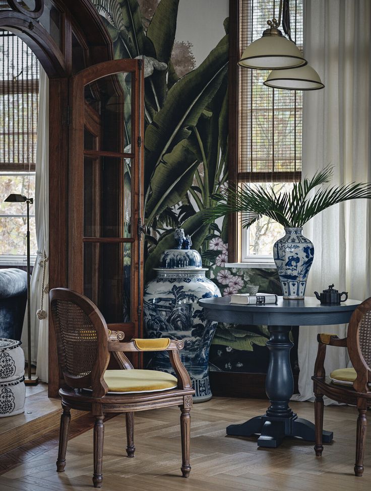 a living room filled with furniture and large potted plants on top of a table