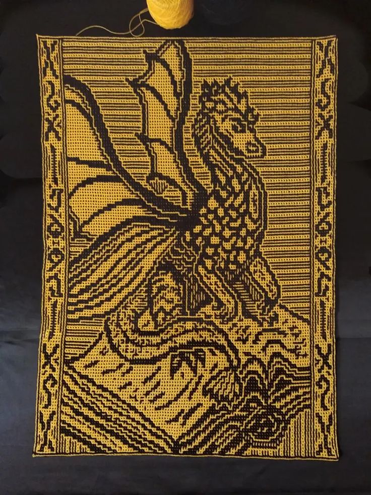 a black and yellow tapestry with a dragon on it's back, next to an orange