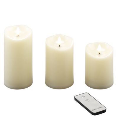 three white candles and a remote control