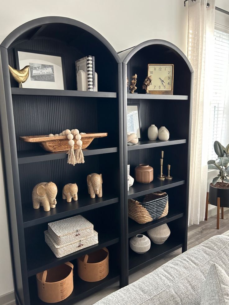 two black bookshelves with different items on them