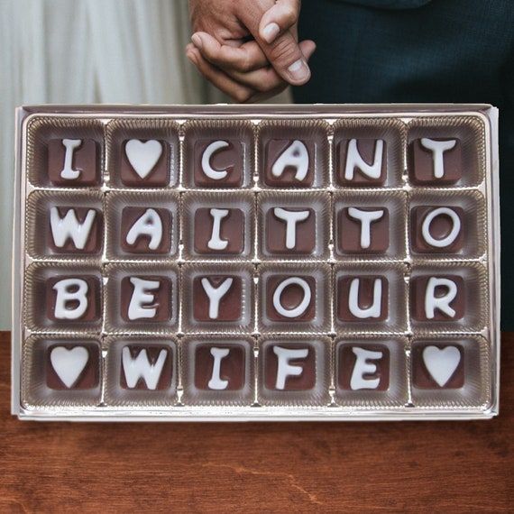 two people holding chocolates that say i can't wait to be your wife