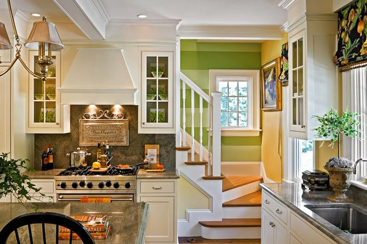 a kitchen with an oven, sink and stairs leading up to the second floor area