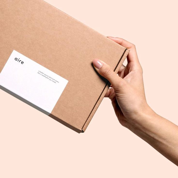 a person's hand is holding an open box with a business card on it