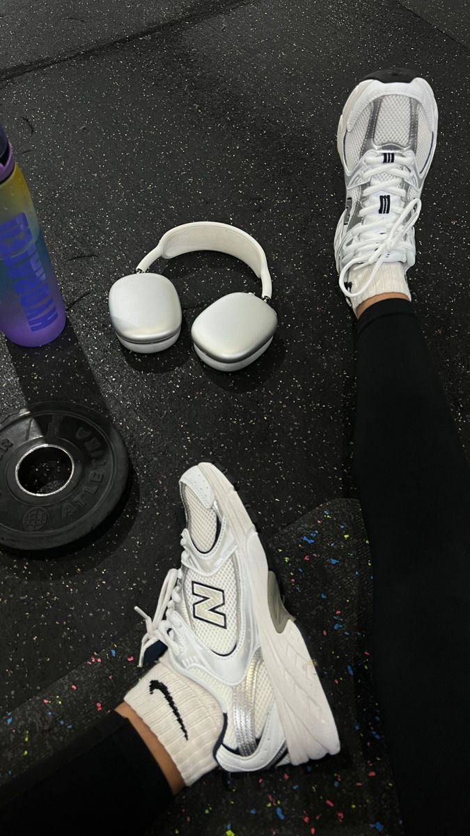 a pair of white sneakers and headphones on the ground