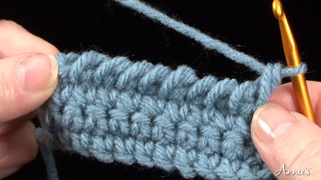 the crochet stitch is being worked on by someone using a small knitting needle