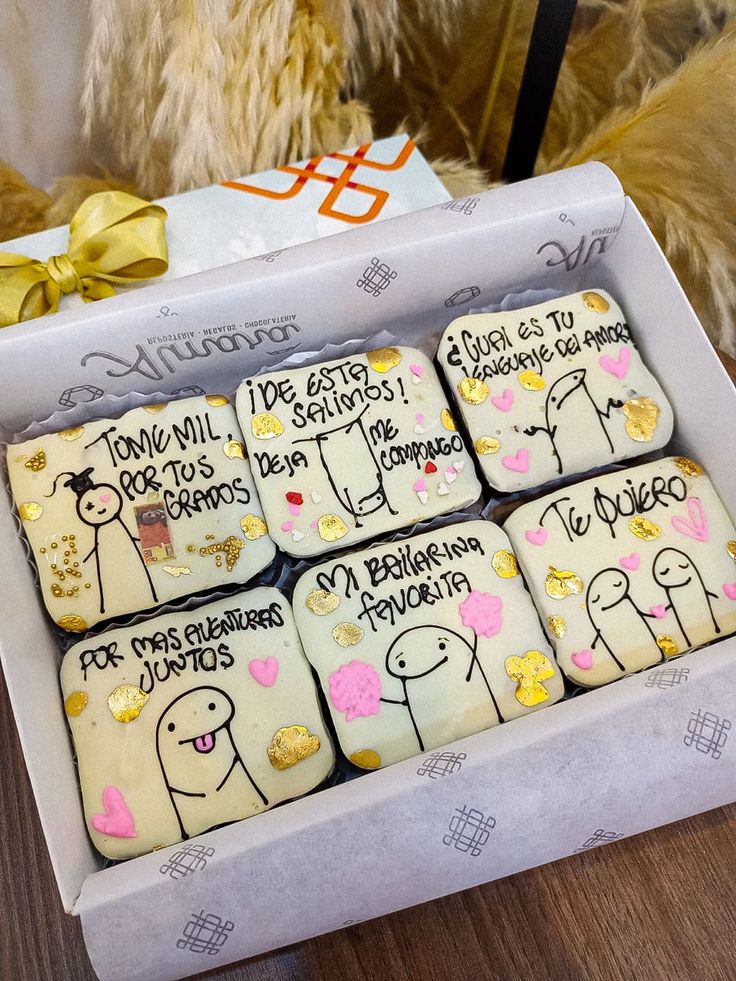 decorated cookies in a box for someone's special occasion, with writing on them