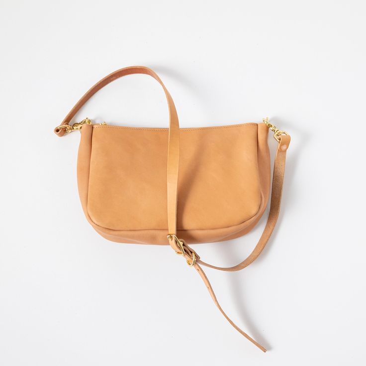 The classic KMM & Co. Crossbody Bag is a perfect everyday companion. Like the other members of the Crossbody Bag family, it's handmade in the USA of beautiful full-grain leather. It comes standard with a solid brass zipper to keep your belongings secure and solid brass D-rings to attach a crossbody or shoulder strap. Choose from a crossbody strap made in the same leather as your bag — like a vintage-inspired chain link strap, a super-adjustable slider strap, or a squishy two-ply strap — or go wi Classic Leather Tote, Leather Crossbody Bags, Custom Strap, Leather Tote Bags, Carryall Tote, Mini Bucket Bags, Perfect Handbag, Leather Handbags Crossbody, Market Tote