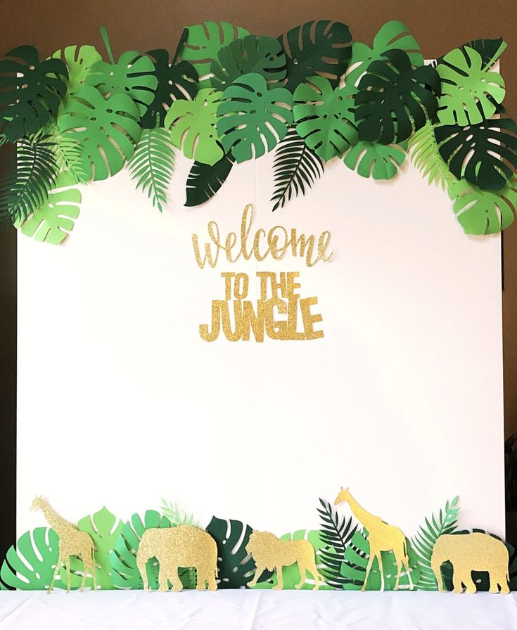 a welcome to the jungle sign surrounded by tropical leaves and giraffe silhouettes