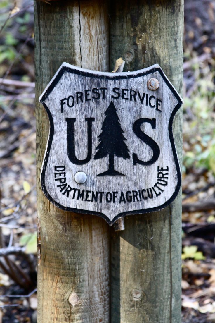 a wooden post with a sign on it stating forest service us s department of agriculture