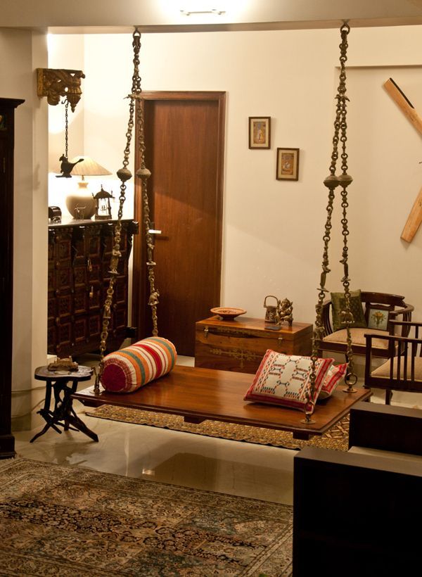 a living room filled with lots of furniture and hanging items on the wall next to a doorway