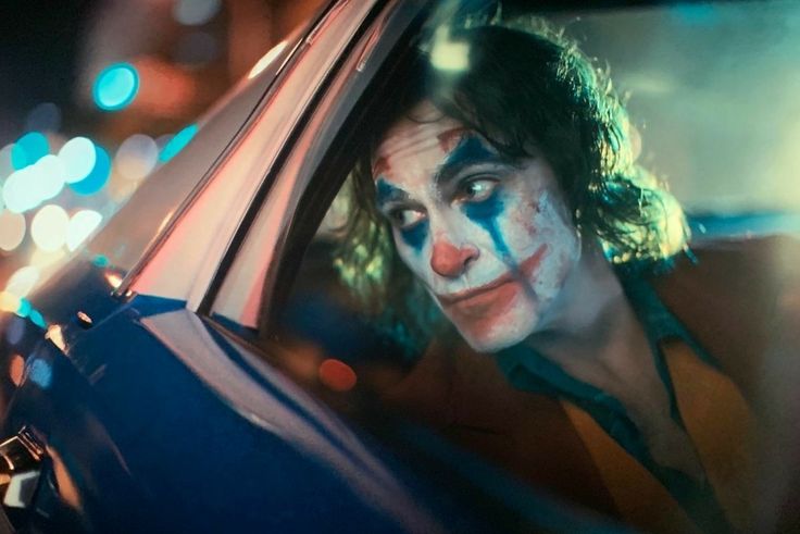 a man dressed as the joker in a car