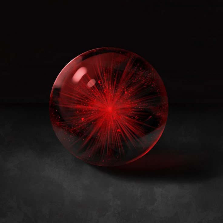 a red ball with fireworks inside on a black surface in front of a dark background