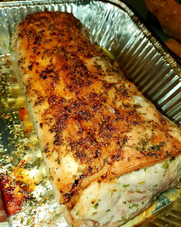 a piece of fish sitting on top of tin foil covered in seasoning and spices