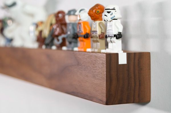 star wars figurines are lined up on a wooden shelf in front of a white wall