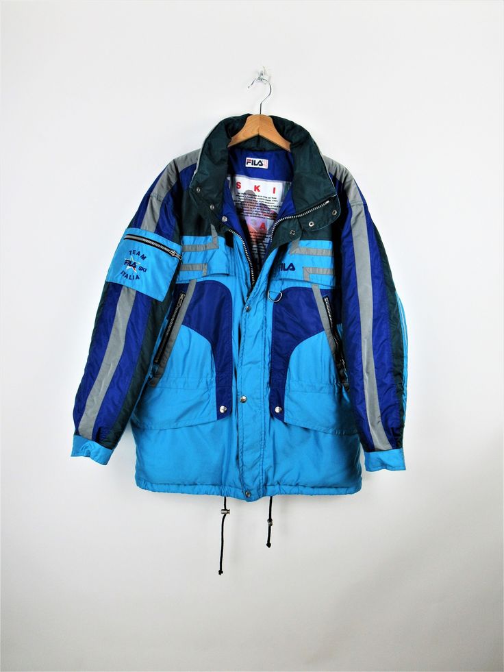 Fila Ski Team Italia vintage 90s padded ski jacket, blue, light blue, green and gray, hood inside the collar, 6 front pockets with zip and 1 on the arm Size XL Measures: Neck/wrist length: 82 cm Length: 83 cm Armpit to armpit width: 67 cm PERFECT - No signs of wear Our garments are all vintage and second-hand. Any signs of wear or defects are documented with photos and description. For any questions, photos, videos we are at your disposal. Urban Blue Winter Parka, Blue Windbreaker With Pockets For Cold Weather, Blue Hooded Windbreaker For Winter Sports, Blue Hooded Outerwear For Winter Sports, Hooded Blue Outerwear For Winter Sports, Blue Long Sleeve Skiing Jacket, Blue Long Sleeve Outerwear For Skiing, Blue Sporty Skiing Outerwear, Retro Hooded Outerwear For Ski Season